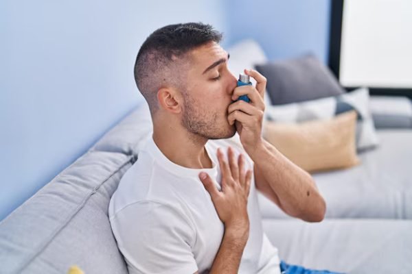 young-hispanic-man-using-inhaler-sitting-sofa-home_839833-7372